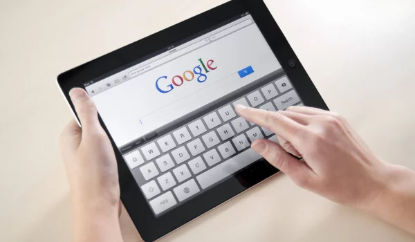Person accessing Google search engine homepage on their tablet device