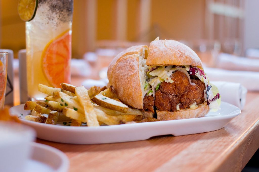 Plate of delicious french fries and fried chicken sandwich served at Perch + Plow