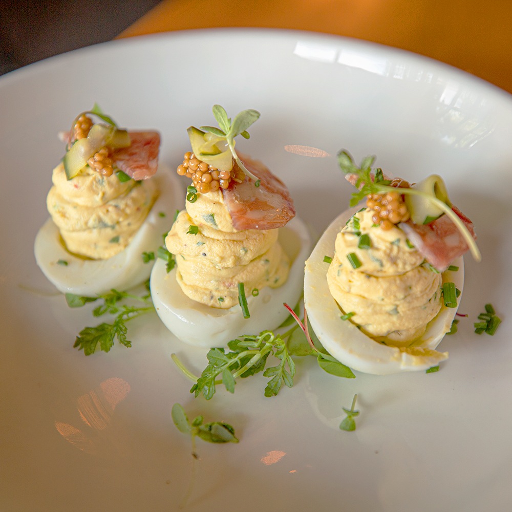 Delicious deviled eggs garnished with bacon and caviar served at Seared Petaluma