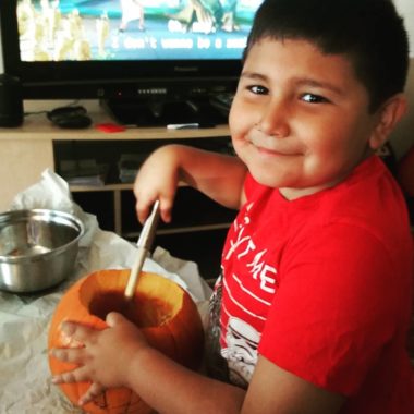 Young child carving pumpkin for Halloween