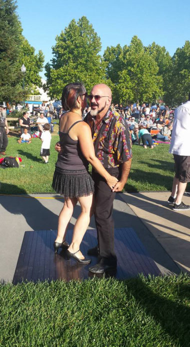 woman in short black dress dancing with man outdoors