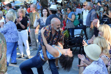 man dipping woman while dancing in a crowd