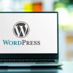 Open laptop on tabletop with the WordPress Logo filling screen