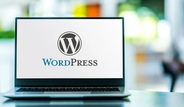 Open laptop on tabletop with the WordPress Logo filling screen